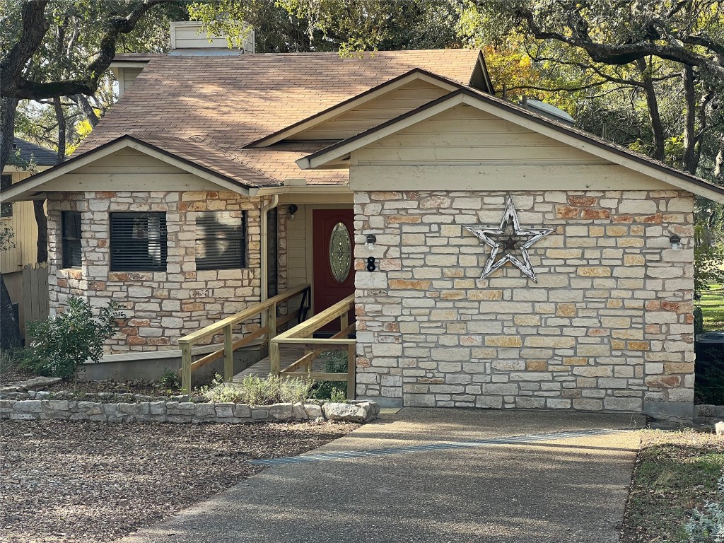 8 Stonehouse Circle Wimberley, TX 78676 - Photo 2 of 18 a front view of a house with garage