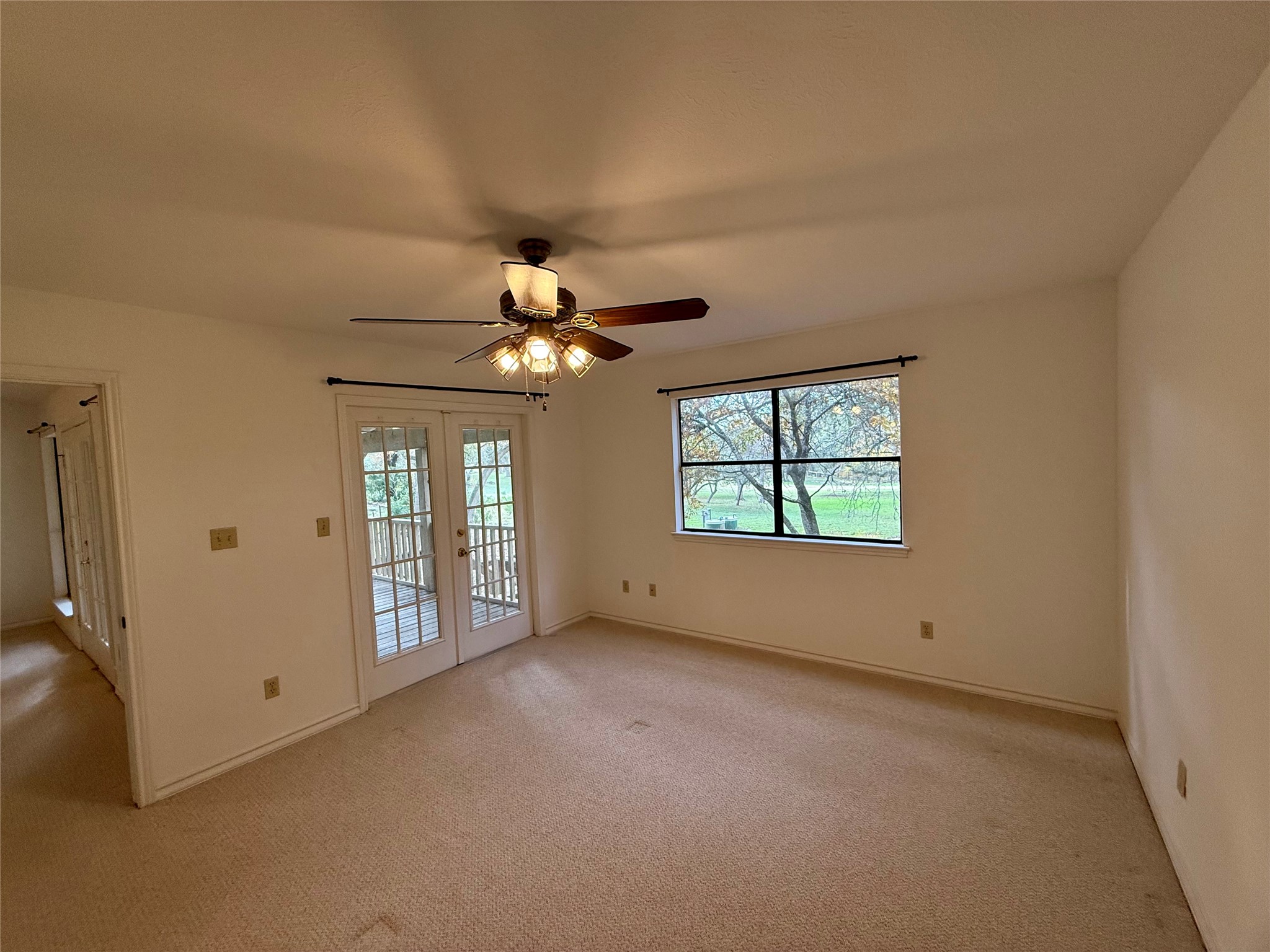 8 Stonehouse Circle Wimberley, TX 78676 - Photo 9 of 18 an empty room with windows and chandelier fan