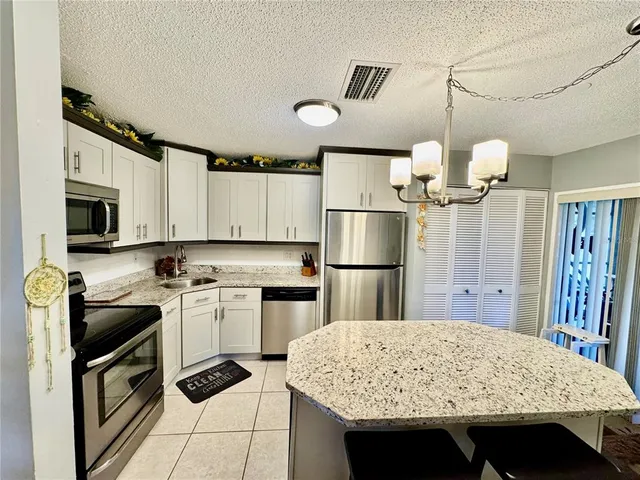 a kitchen with stainless steel appliances granite countertop sink refrigerator and microwave