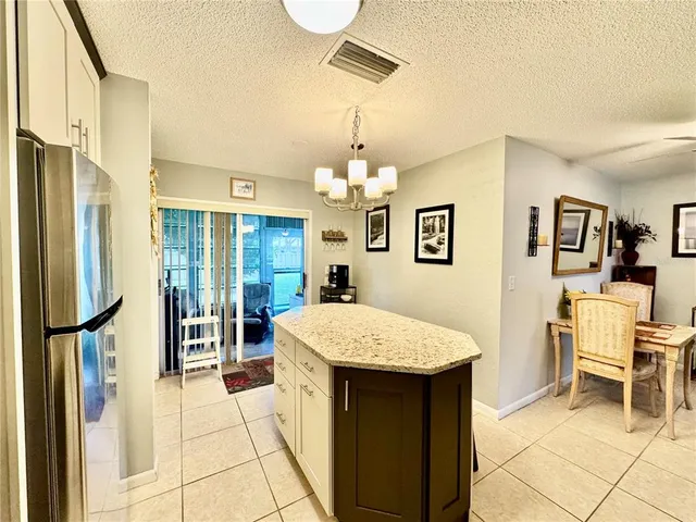 a large bed sitting in a kitchen next to a refrigerator