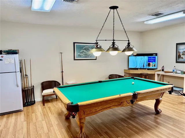 a room with pool table and wooden floor