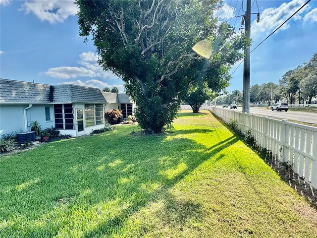 a view of a backyard with table and chairs and a large tree