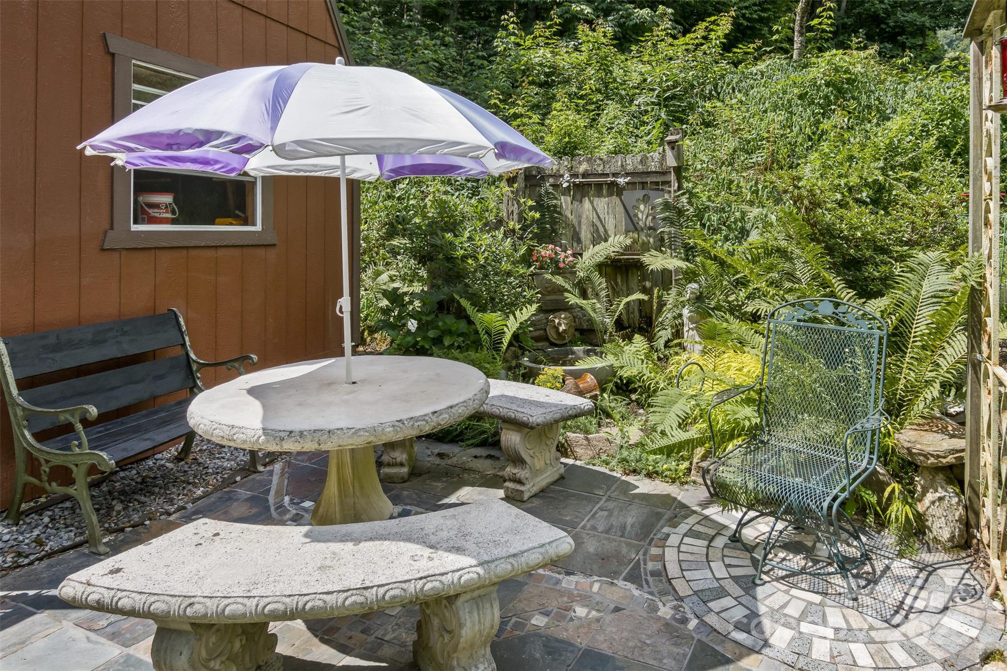 557 Tumbling Fork Road Waynesville, NC 28785 - Photo 40 of 44 a view of a patio with table and chairs under an umbrella