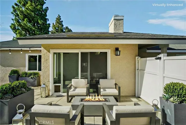 a view of a patio with table and chairs potted plants and floor to ceiling window