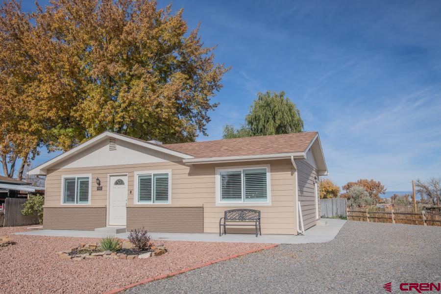 490 6403 Road Montrose, CO 81403 - Photo 2 of 40 a front view of a house with a yard and garage