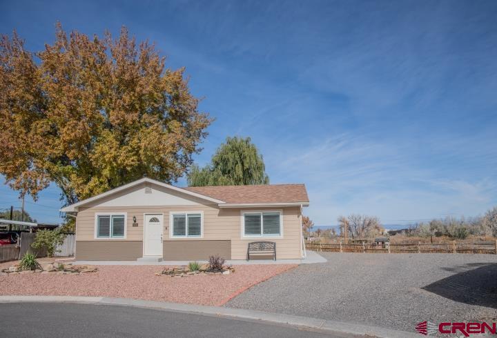 490 6403 Road Montrose, CO 81403 - Photo 3 of 40 a front view of a house with a yard and trees