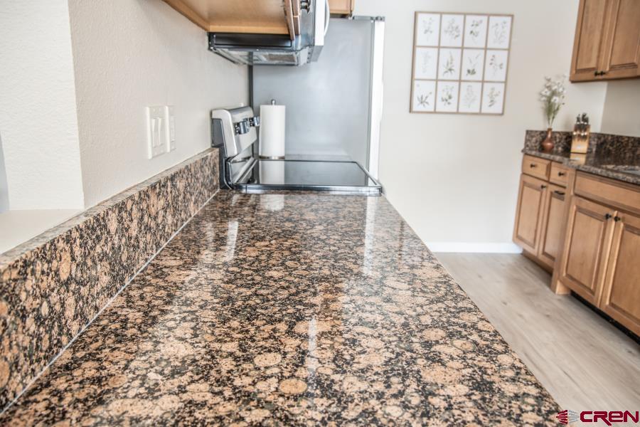 490 6403 Road Montrose, CO 81403 - Photo 8 of 40 a kitchen with granite countertop a stove a sink and a refrigerator