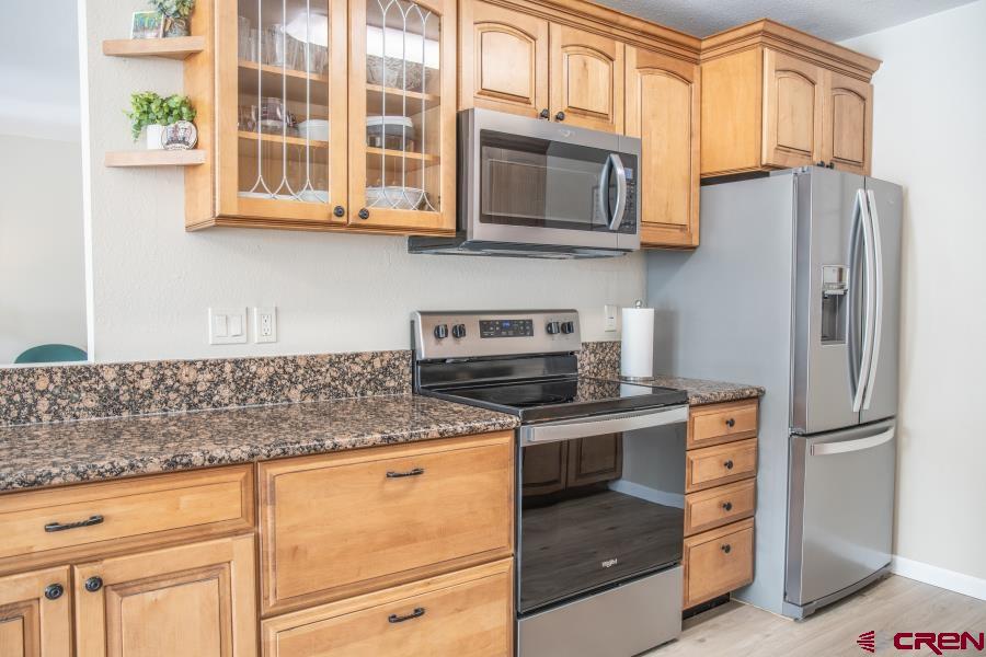 490 6403 Road Montrose, CO 81403 - Photo 9 of 40 a kitchen with stainless steel appliances granite countertop a stove microwave and refrigerator
