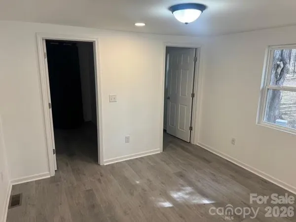 an empty room with windows and closet