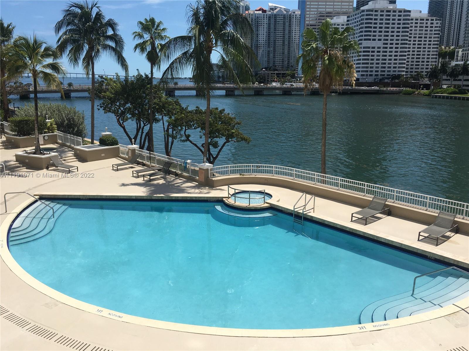 701 Brickell Key Boulevard, Unit 1502 Miami, FL 33131 - Photo 16 of 21 a view of a swimming pool with a table and chairs