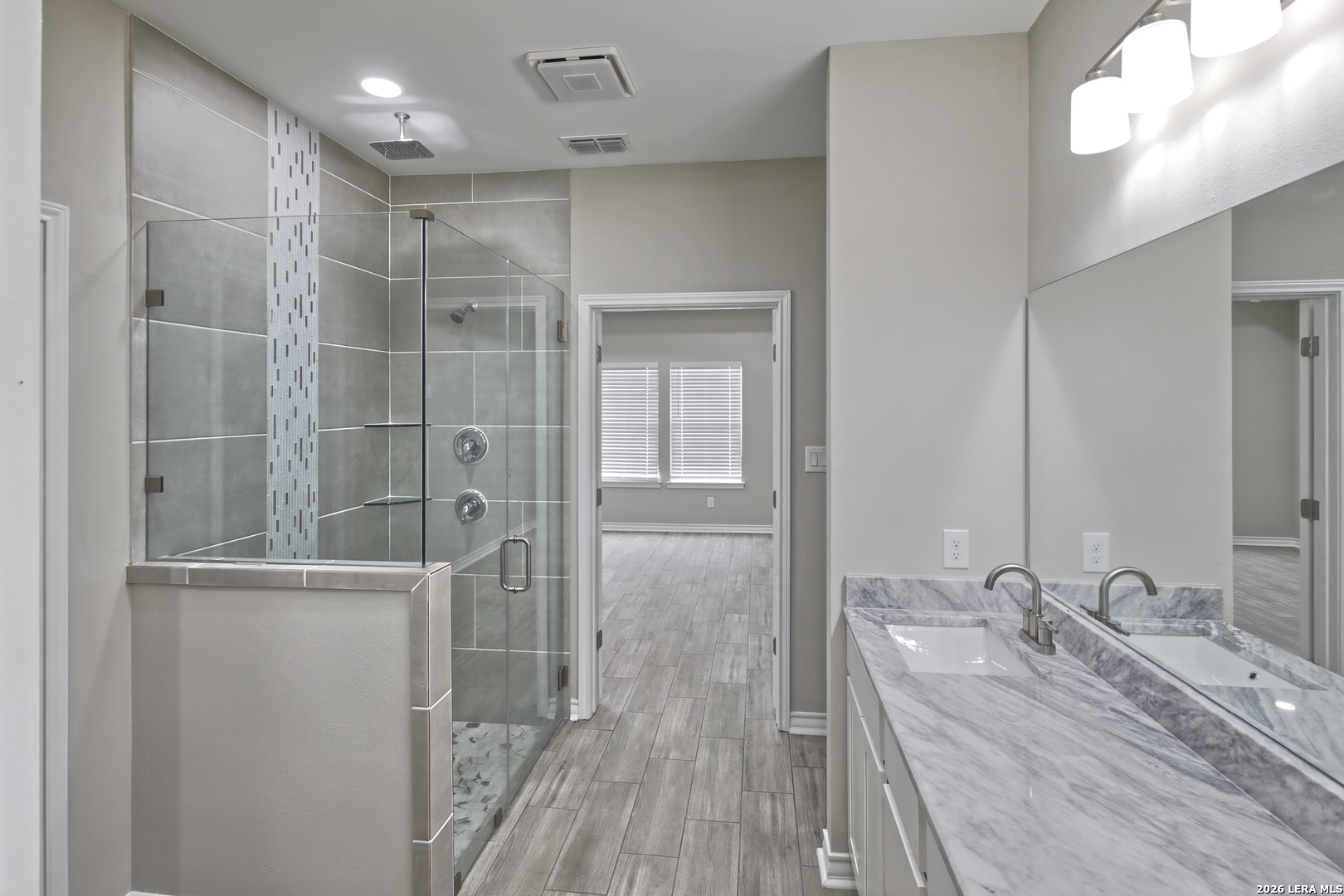 918 Marbach Road Somerset, TX 78069 - Photo 20 of 36 a bathroom with a double vanity sink a mirror and shower