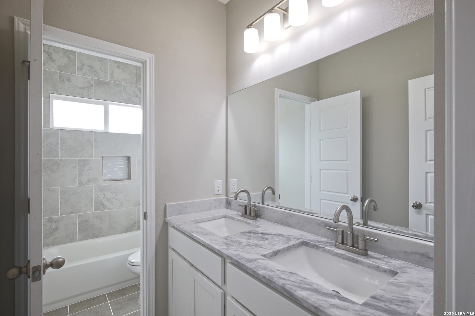 918 Marbach Road Somerset, TX 78069 - Photo 24 of 36 a bathroom with a granite countertop sink a mirror and a shower