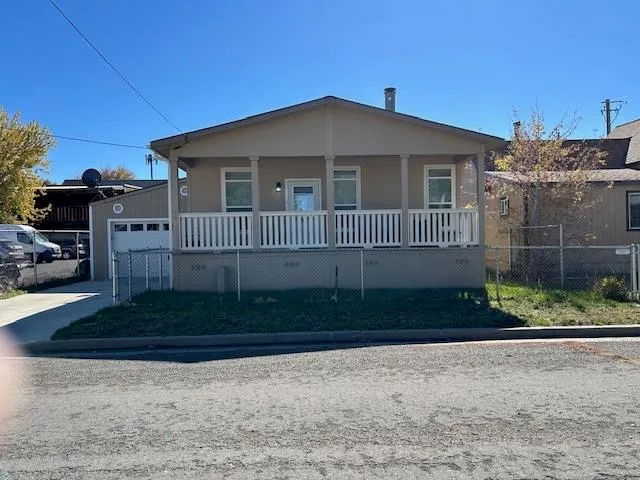a view of a house with a small yard and wooden fence