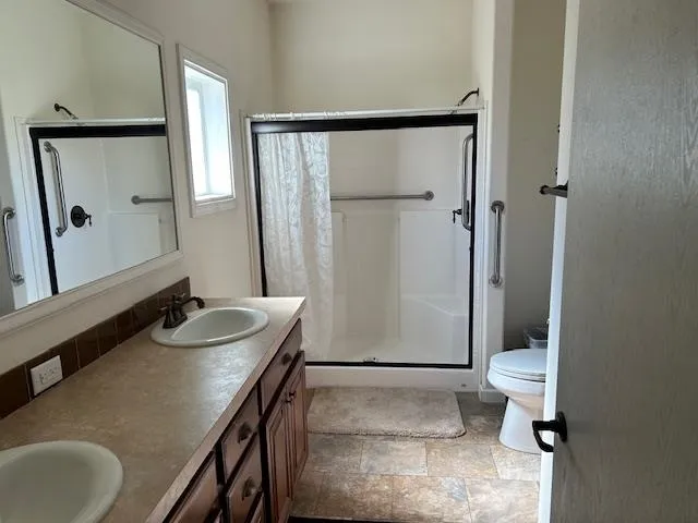 a bathroom with a granite countertop sink toilet and shower