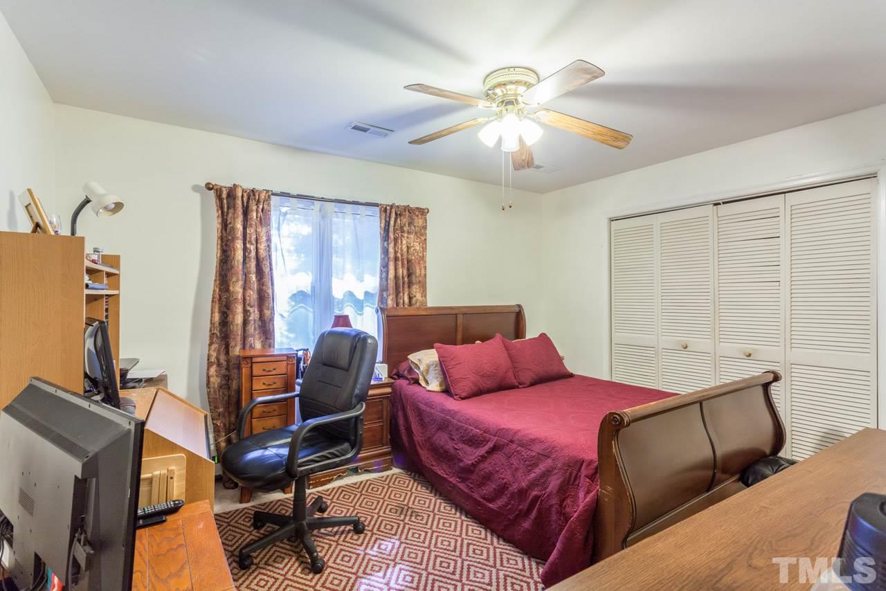 6904 Falls Of Neuse Road, Unit 6904 Raleigh, NC 27615 - Photo 14 of 23 a bedroom with a bed and wooden floor