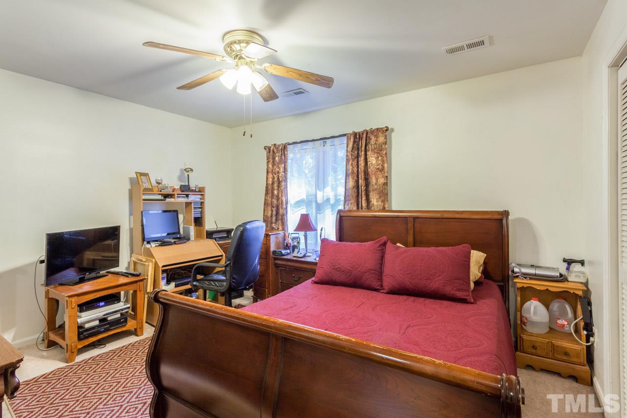 6904 Falls Of Neuse Road, Unit 6904 Raleigh, NC 27615 - Photo 15 of 23 a bedroom with furniture and a flat screen tv