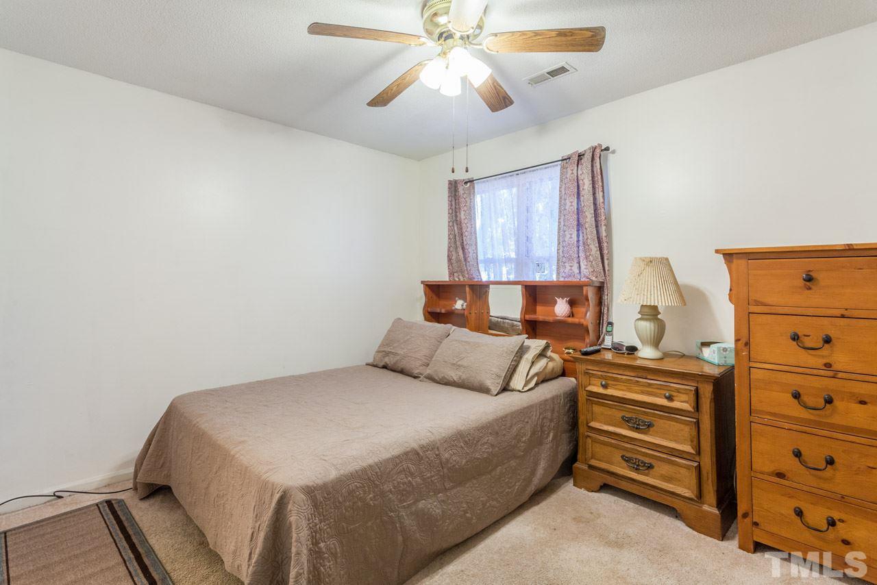 6904 Falls Of Neuse Road, Unit 6904 Raleigh, NC 27615 - Photo 17 of 23 a bedroom with a bed and a chandelier