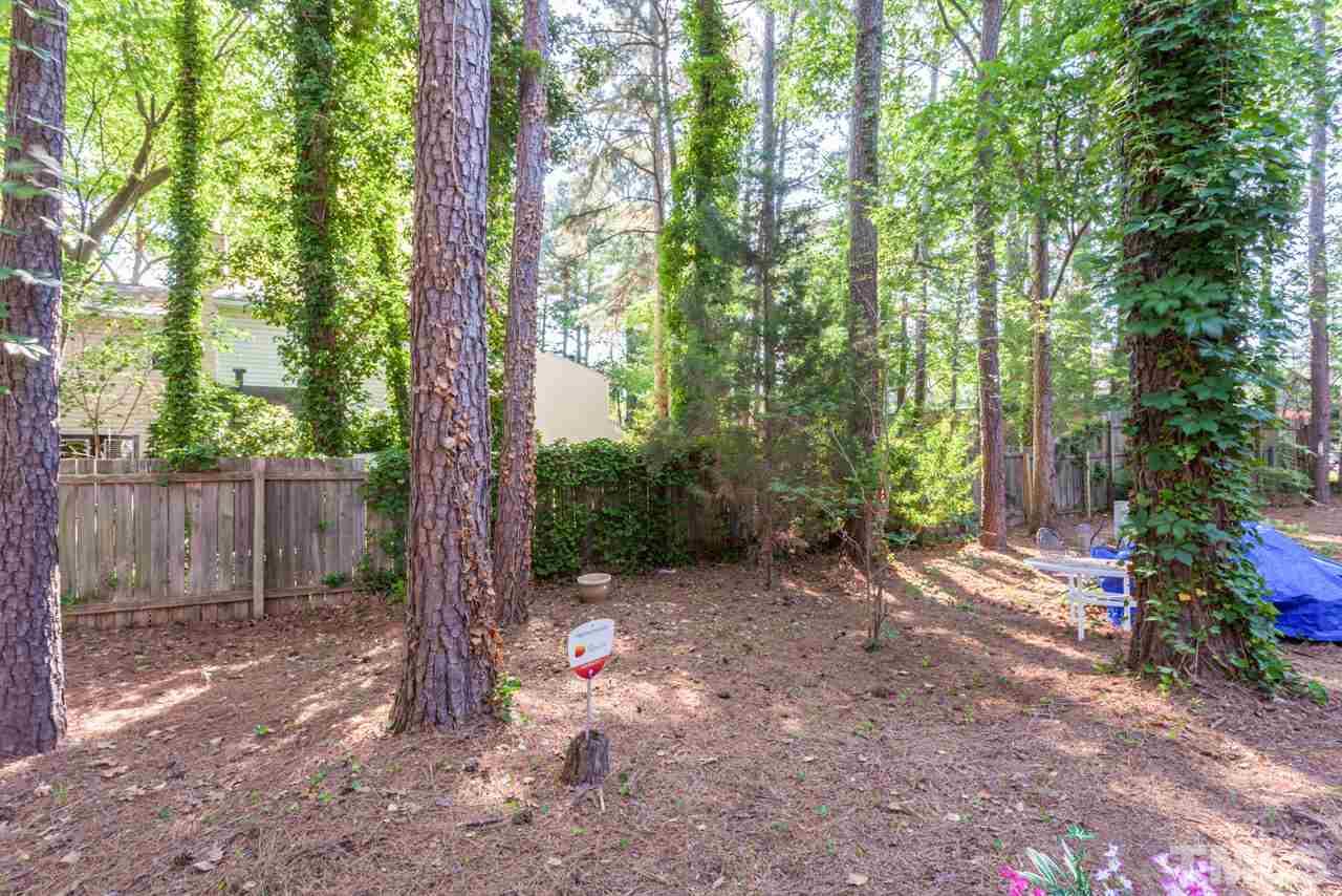 6904 Falls Of Neuse Road, Unit 6904 Raleigh, NC 27615 - Photo 22 of 23 a view of a backyard with large trees and wooden fence