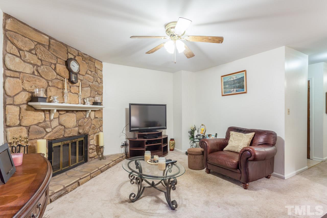 6904 Falls Of Neuse Road, Unit 6904 Raleigh, NC 27615 - Photo 4 of 23 a living room with furniture a flat screen tv and a fireplace