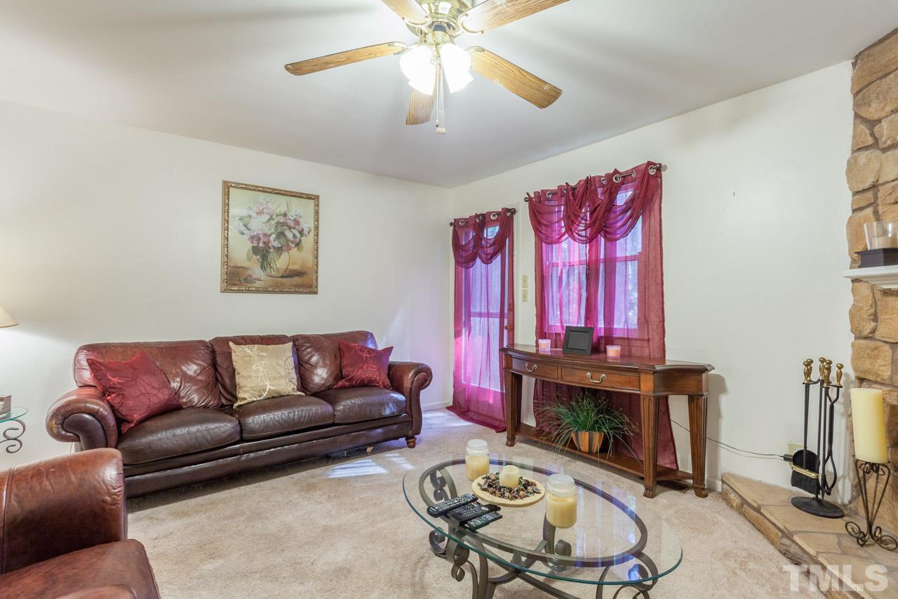 6904 Falls Of Neuse Road, Unit 6904 Raleigh, NC 27615 - Photo 6 of 23 a living room with furniture a fireplace and a flat screen tv