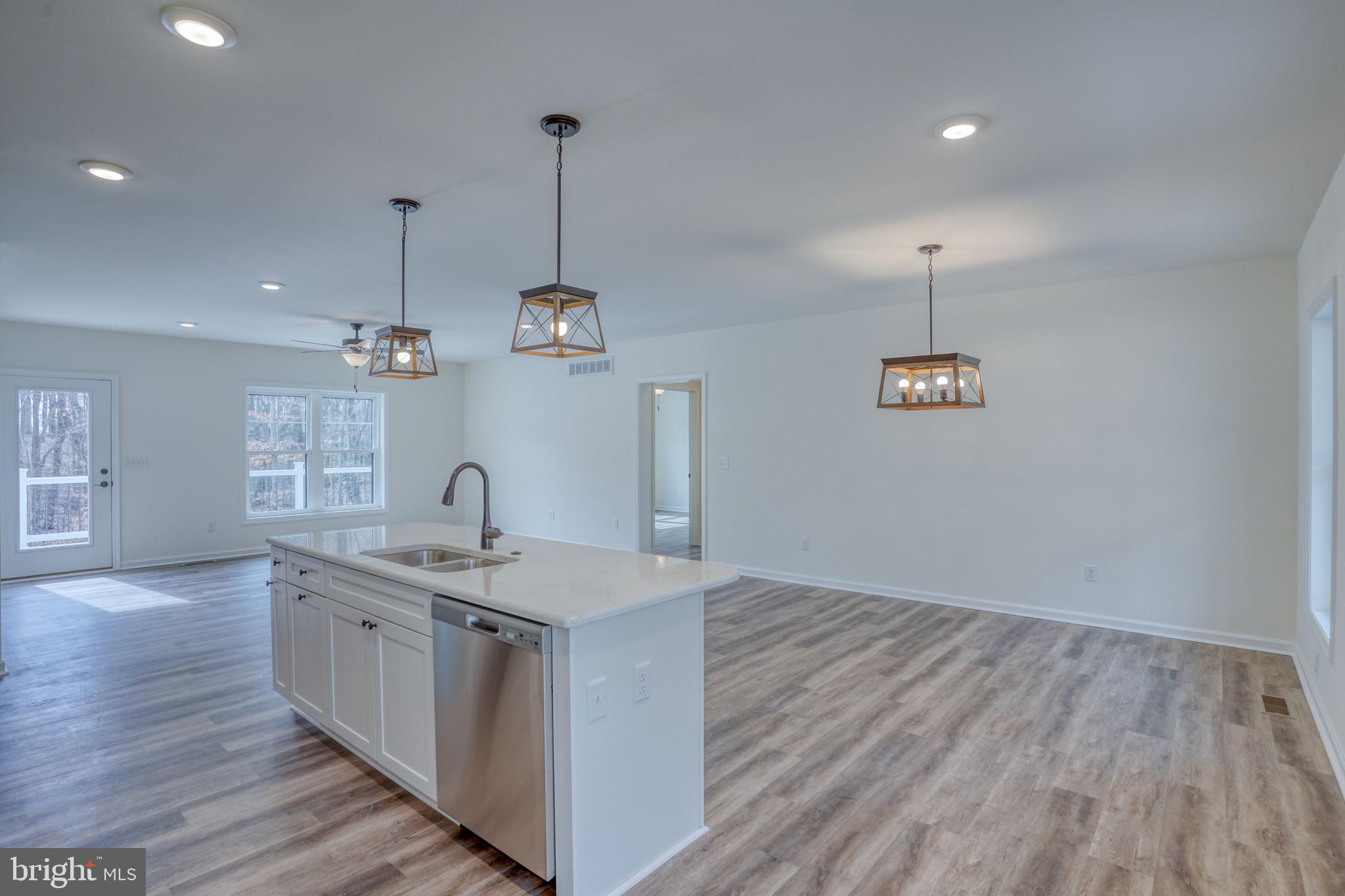 156 Pratts Branch Road Felton, DE 19943 - Photo 13 of 35 a kitchen with a sink chandelier and wooden floor