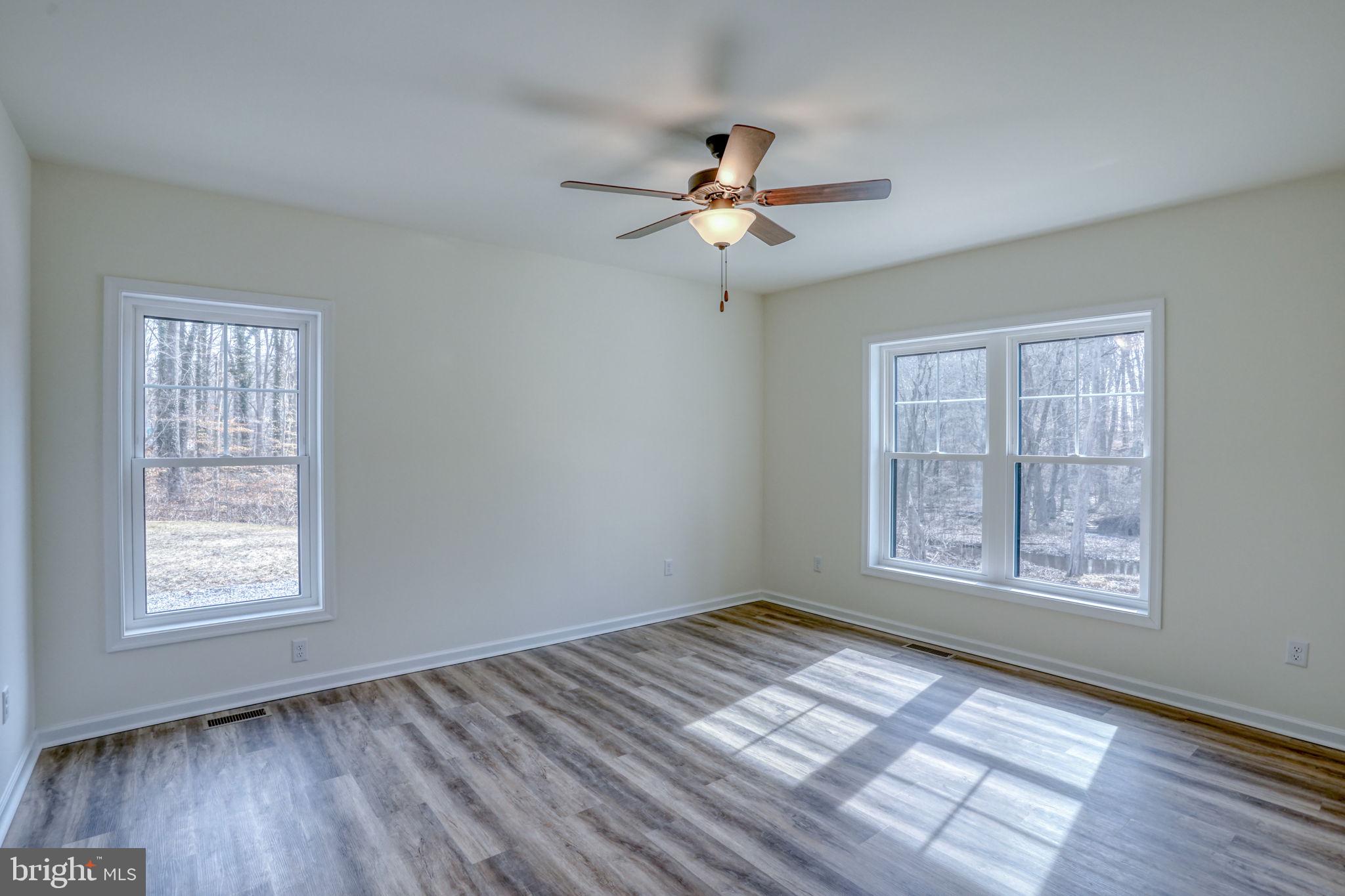 156 Pratts Branch Road Felton, DE 19943 - Photo 16 of 35 a view of empty room with wooden floor and fan