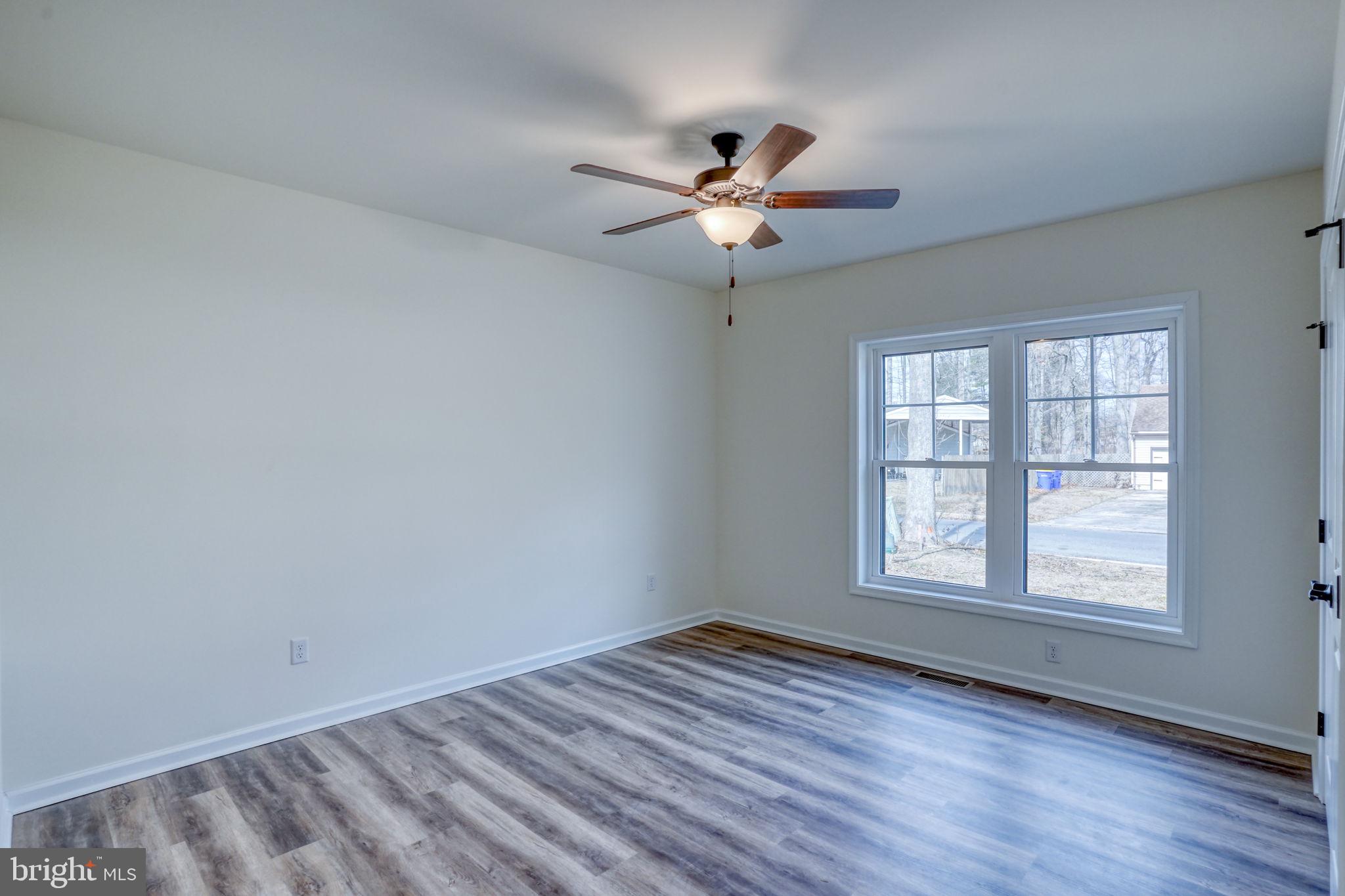 156 Pratts Branch Road Felton, DE 19943 - Photo 24 of 35 an empty room with wooden floor fan and windows