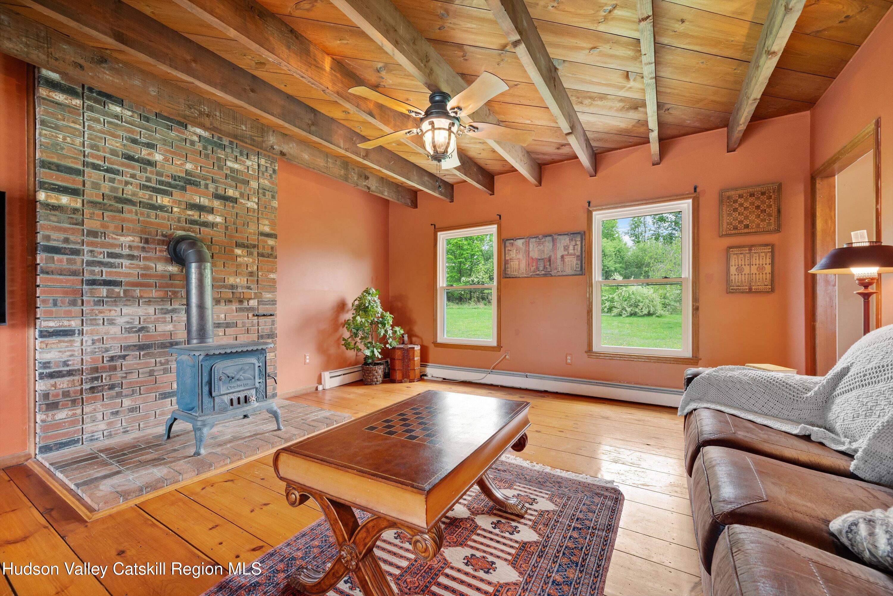 141 East Ridge Road Warwick, NY 10990 - Photo 13 of 57 a living room with furniture a flat screen tv and a floor to ceiling window
