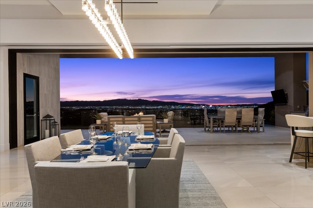 657 Ridgestone Rim Court Henderson, NV 89012 - Photo 8 of 97 Retractable glass doors seamlessly connect the refined indoor dining space to a sweeping mountain-view terrace.