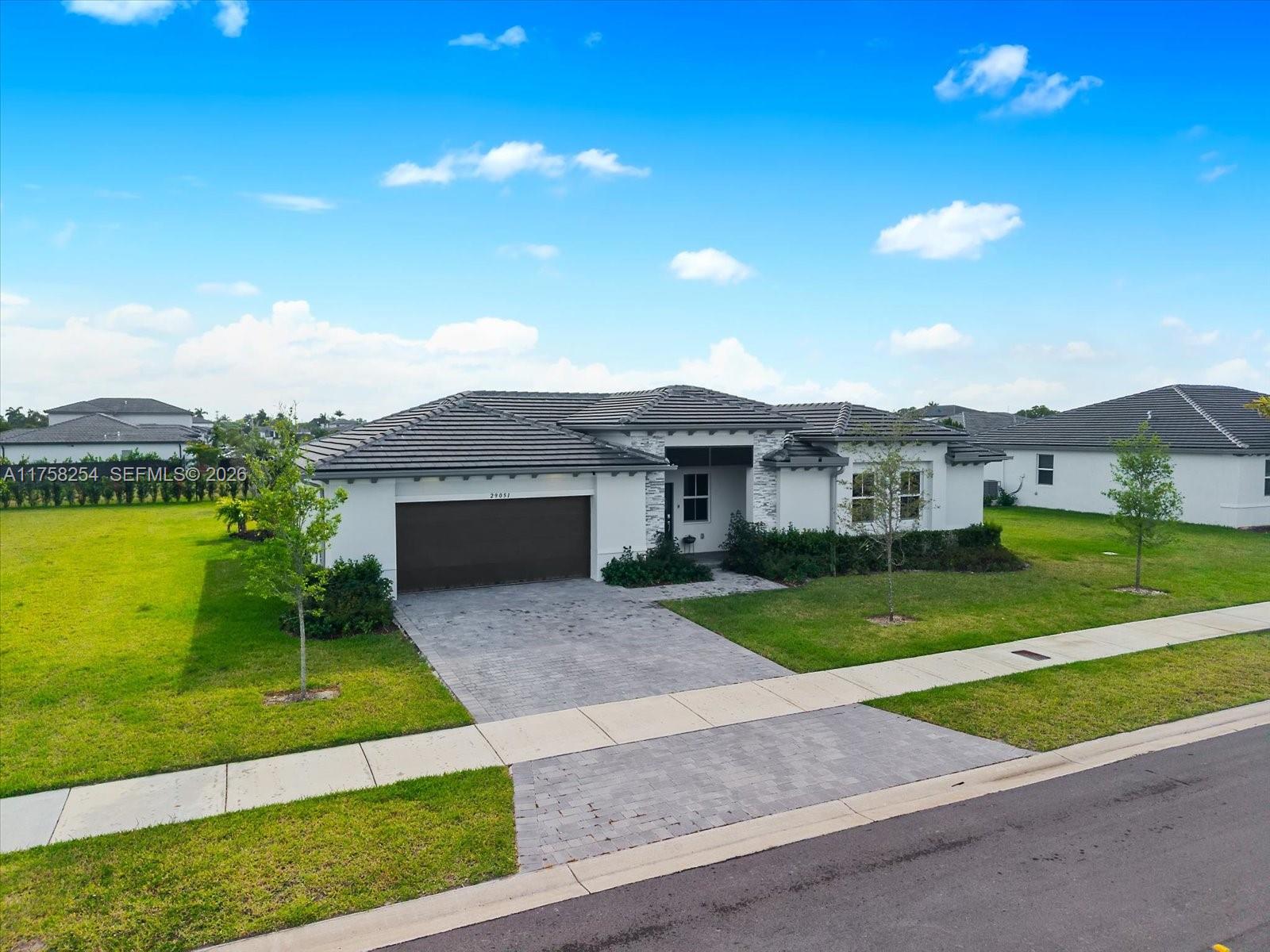29051 Southwest 169th Avenue Homestead, FL 33030 - Photo 1 of 3 a front view of a house with a yard and garage