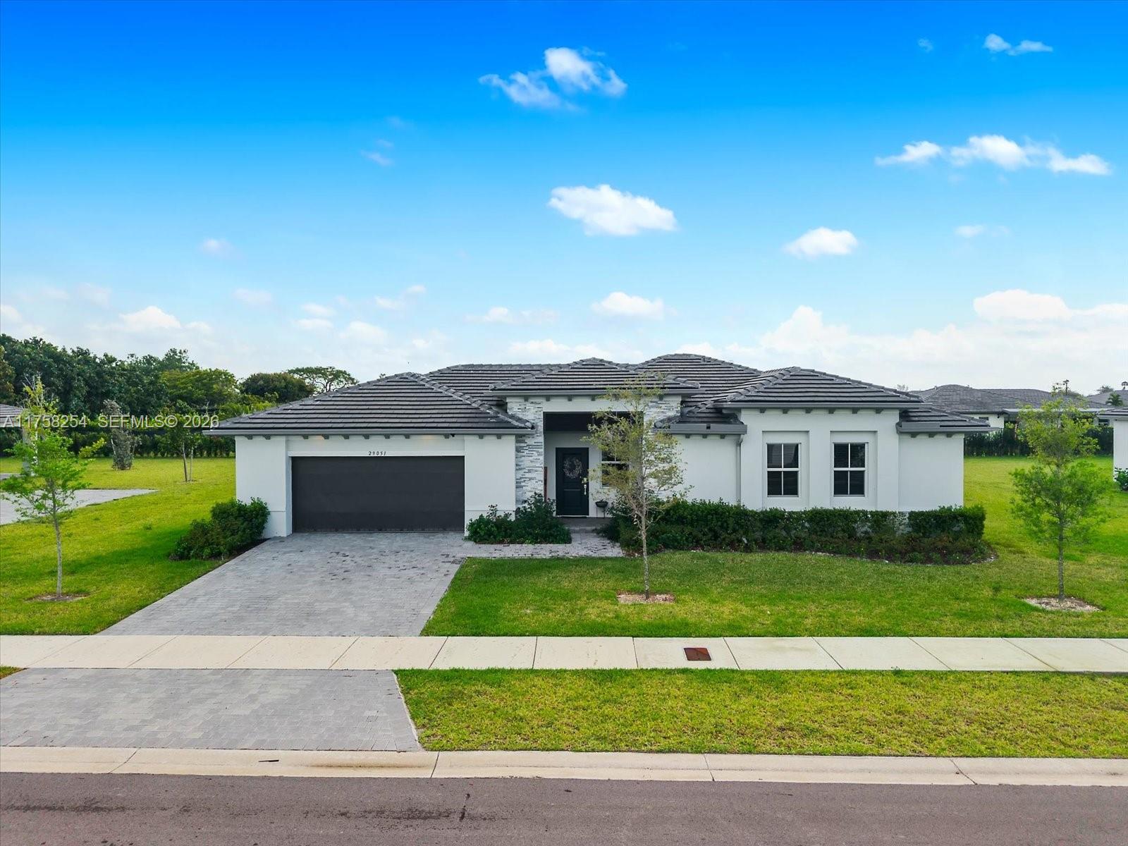 29051 Southwest 169th Avenue Homestead, FL 33030 - Photo 2 of 3 a front view of a house with a garden and yard
