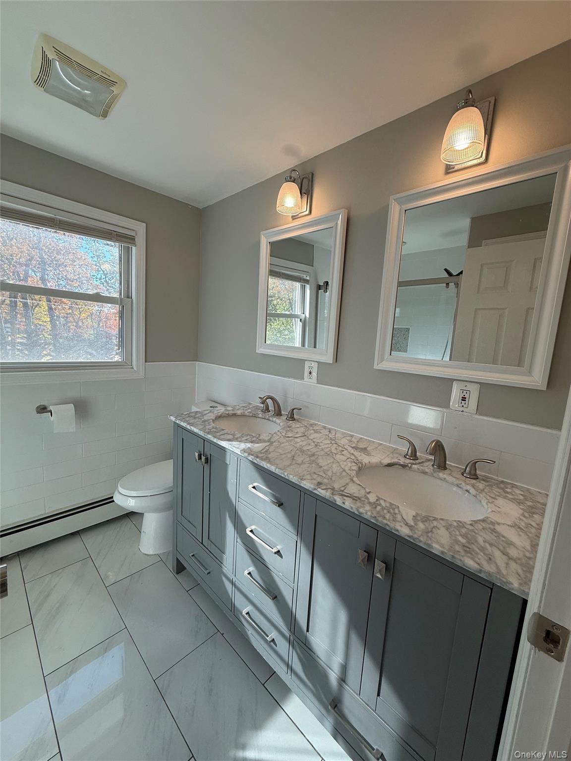 44 Pine Street Blue Point, NY 11715 - Photo 2 of 17 a bathroom with a granite countertop sink a toilet and a mirror