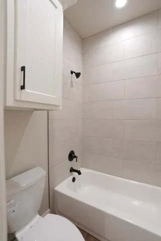 a bathroom with a toilet and a bathtub