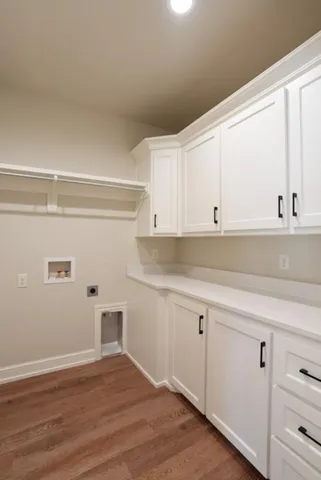 a kitchen with granite countertop white cabinets and wooden floor