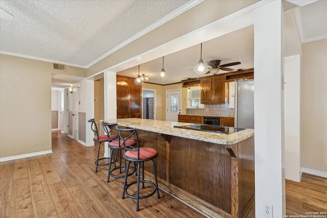 a kitchen with stainless steel appliances granite countertop a sink and a refrigerator