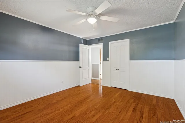 a view of an empty room with wooden floor