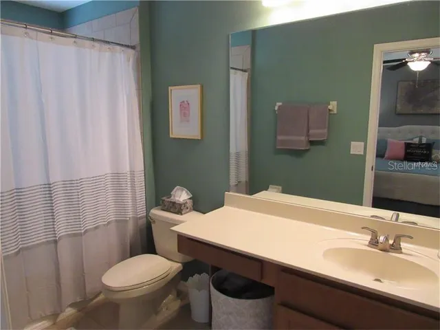 a bathroom with a sink a toilet and shower curtain