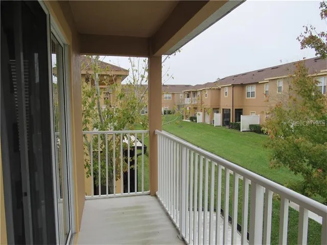 a view of a balcony with a yard