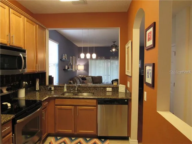 a kitchen with stainless steel appliances granite countertop a sink and a stove