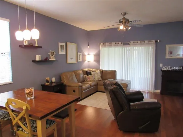 a living room with furniture a chandelier and a flat screen tv