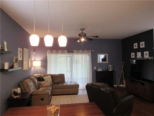 a living room with furniture a chandelier and a flat screen tv
