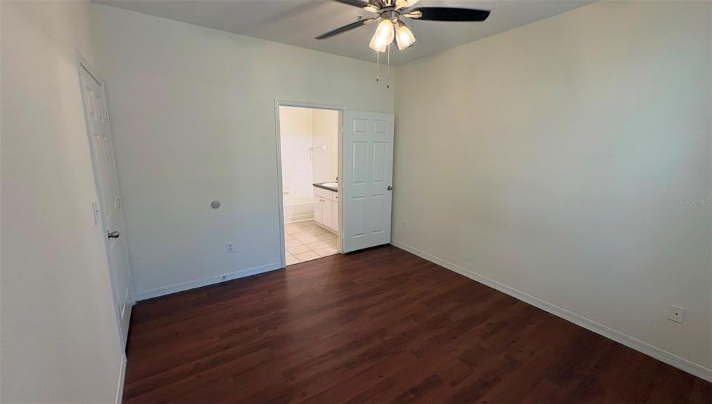 6348 Raleigh Street, Unit 1304 Orlando, FL 32835 - Photo 12 of 20 an empty room with wooden floor chandelier fan and windows