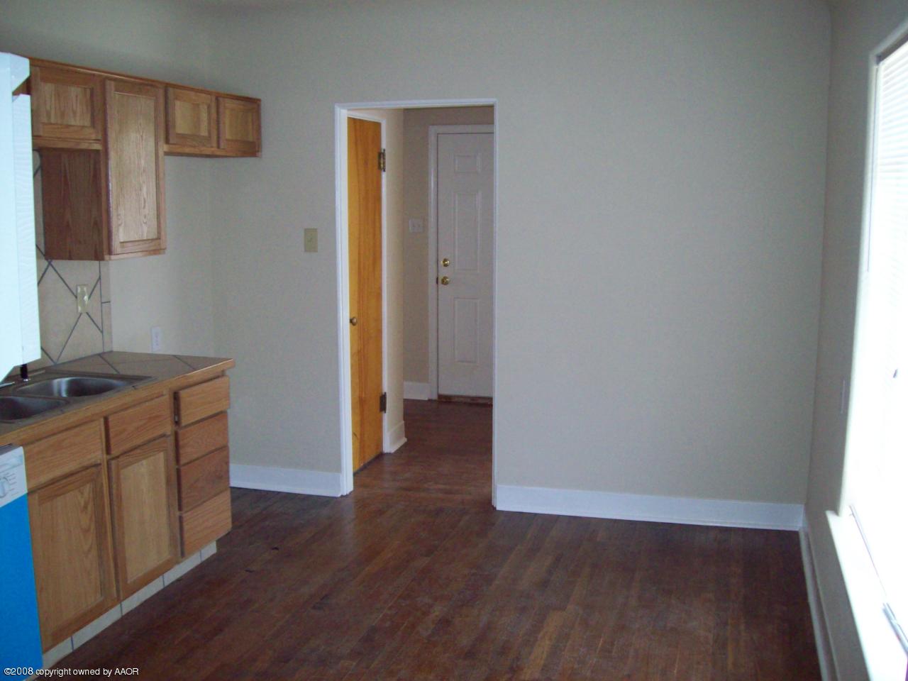 3711 South Polk Street Amarillo, TX 79110 - Photo 14 of 20 a view of a kitchen with wooden floor and cabinets