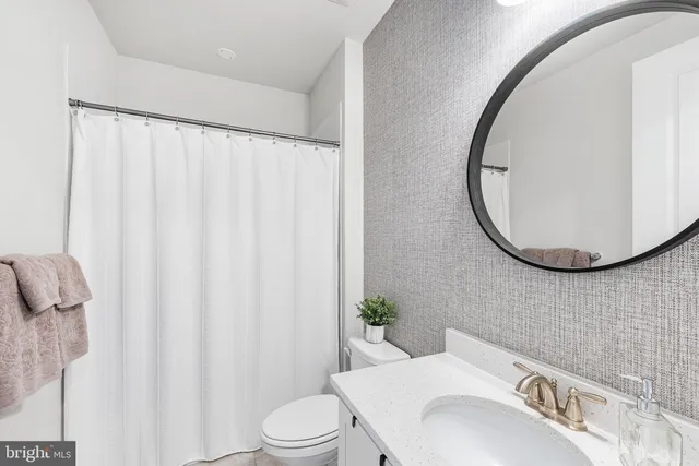 a bathroom with a sink a toilet and a mirror