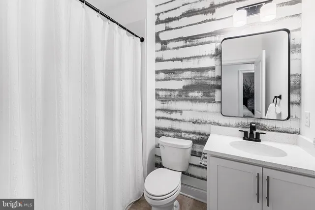 a bathroom with a toilet a sink and a mirror