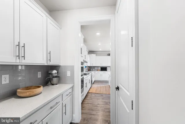 a kitchen with white cabinets and sink