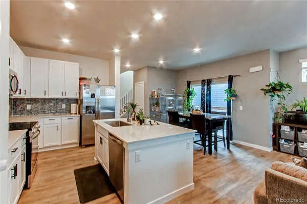 a open kitchen with white cabinets and stainless steel appliances