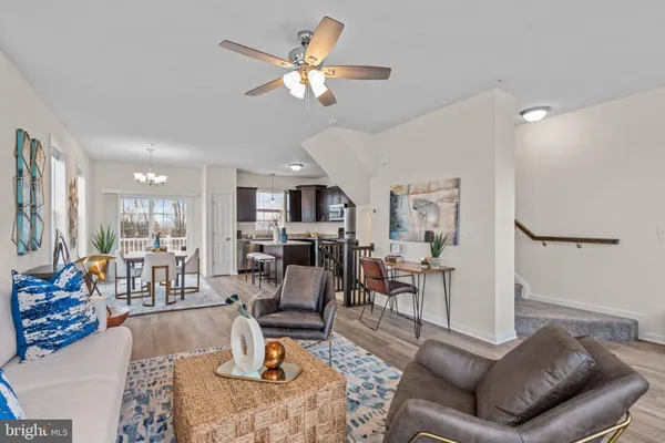 a living room with furniture and a large mirror with wooden floor