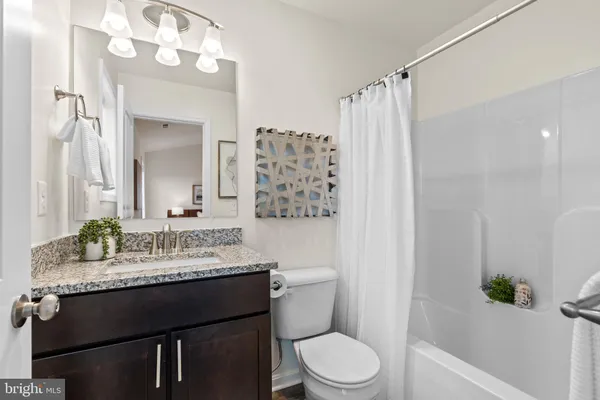 a bathroom with a sink a toilet a mirror and shower