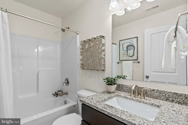 a bathroom with a granite countertop sink a mirror a shower and a bathtub